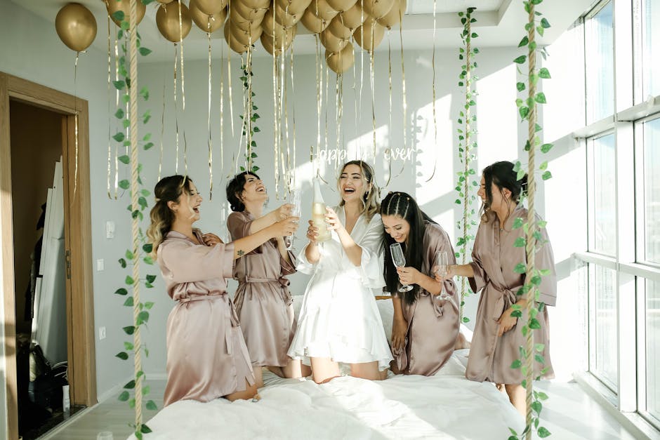Joyful bridal party enjoying champagne amidst elegant decor indoors.